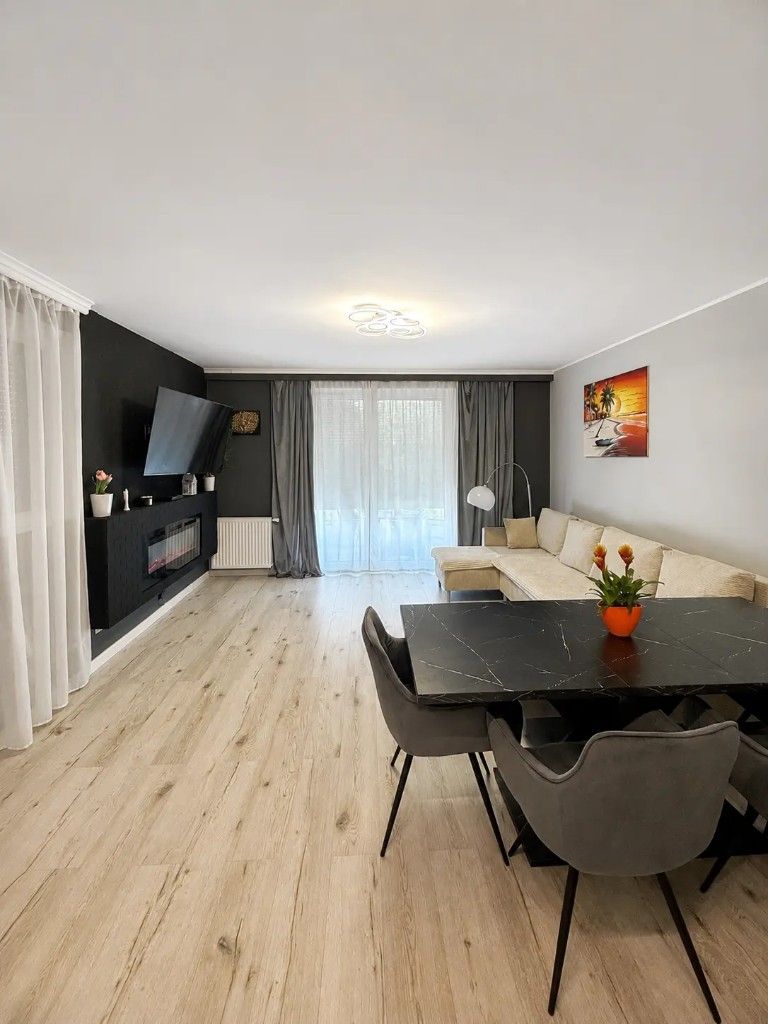 Jasny salon ze stołem jadalnym i telewizorem w Baltic Garden Apartment, Gdańsk